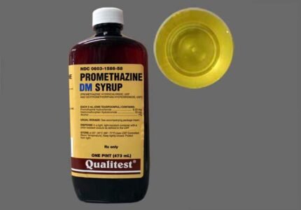 Promethazine DM syrup fles met maatbeker en verpakkingsdoos op een wit oppervlak