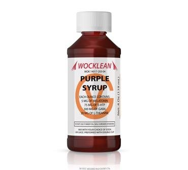 WOCKLEAN Purple Syrup fles naast een gevuld glas frisdrank op een houten tafel