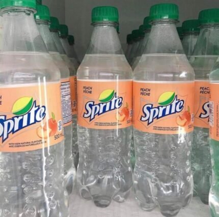 Sprite codeine fles naast een koud glas frisdrank met ijs en snoepjes op een houten tafel
